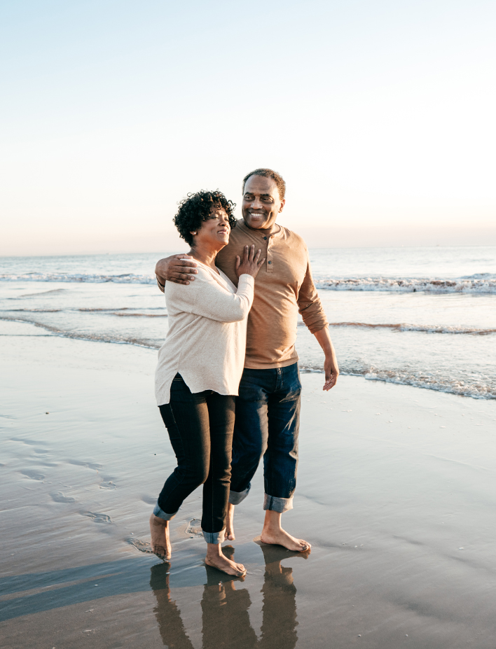 couple walking on the beach holding each other