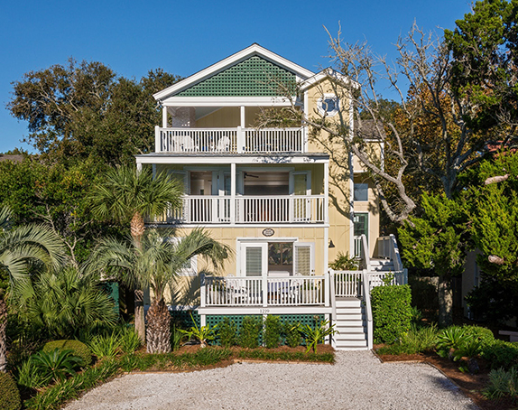 three story beach house with porch and balconies on each level