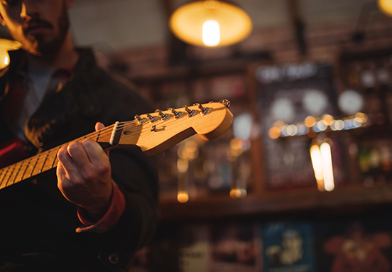 close up of a man playing a guitar