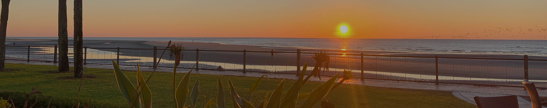 peaceful sunsetting over ocean while waves come up the sand at the beach of resort