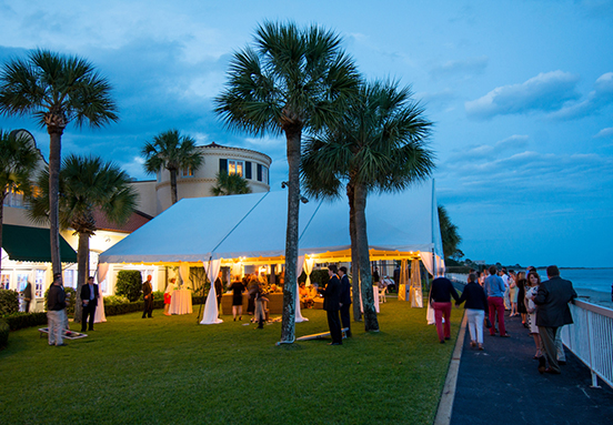 guests mingling under a large tent in an outdoor venue space