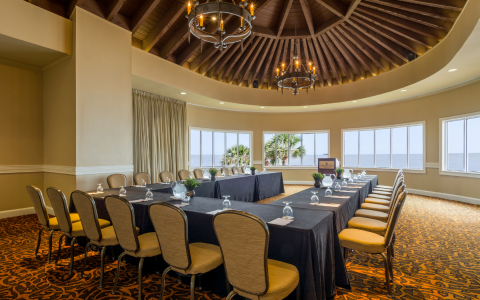 conference table in a U shape with chairs around with ocean view