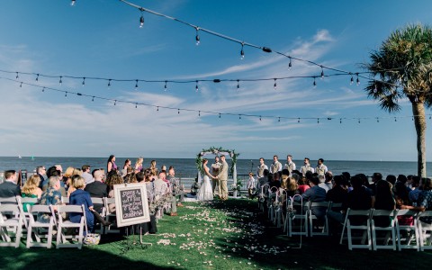 view of the bride and groom at the altar at the oceanfront lawn