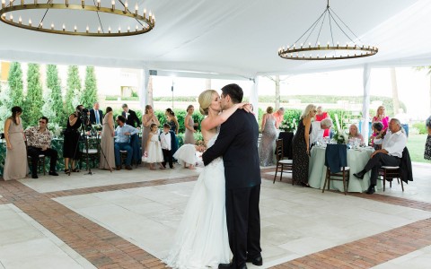 bride and groom kissing while sharing a dance at their reception