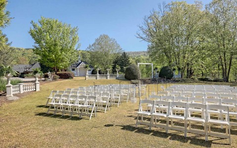 view of all decoration and furniture set up for a wedding in the nature at daytime