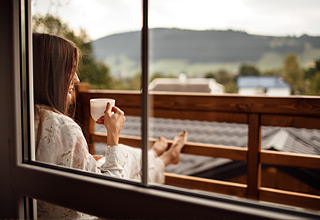  woman having a coffee at her balcony