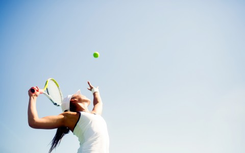 Woman playing tennis looking at the ball 