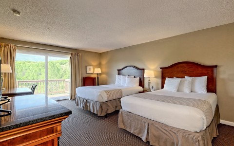 View of a traditional double hotel room with features as two double beds and a balcony