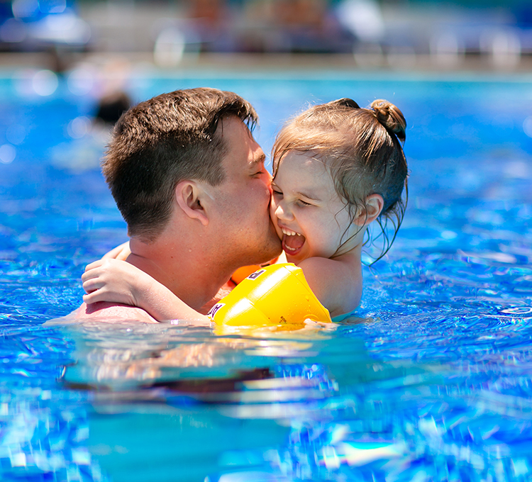 Father and his kid enjoying the swimming pool 