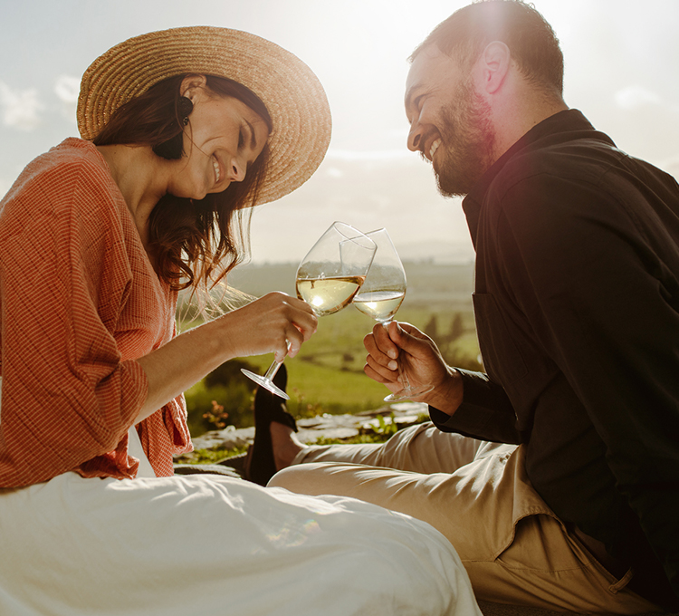 Couple smiling making a toast with white wine