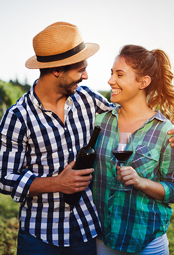 Two people smiling and looking at each other with a merlot in their hands