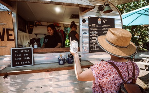 a woman getting shave ice at a local stand