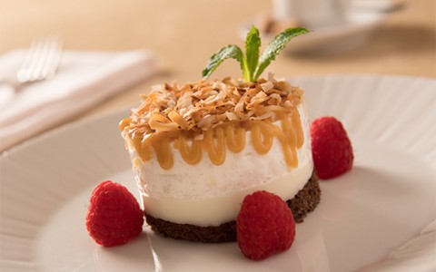 close up view of an elegant dessert with raspberries served on a white plate