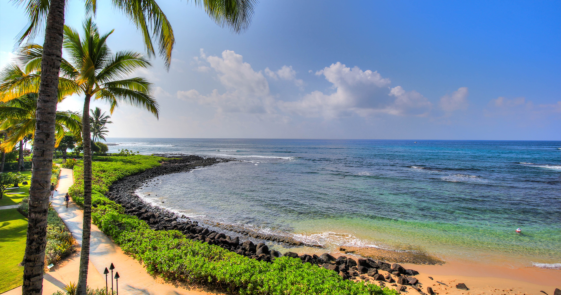 view of the ocean with several black rocks along the shore