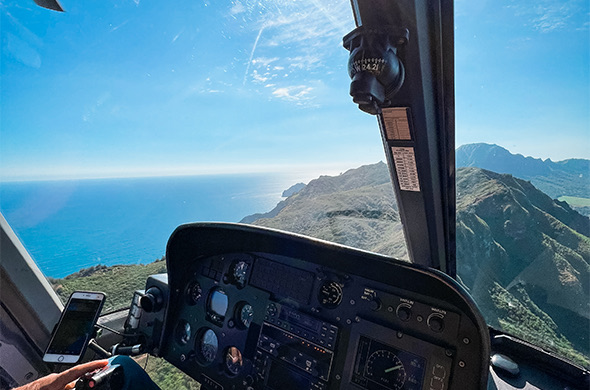 view of the ocean and the mountains from a helicopter