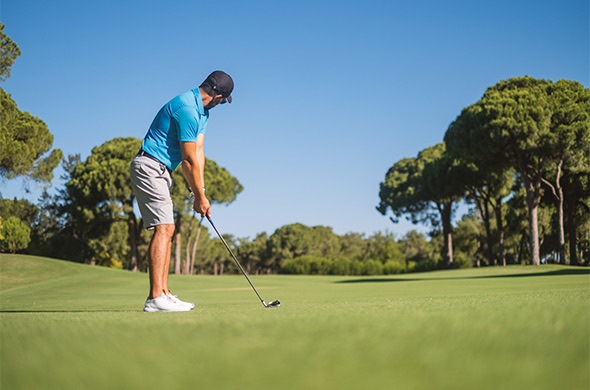 a man golfing at an empty course on a sunny day