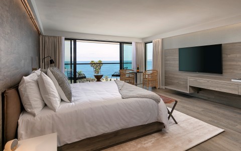 large king bed in room with flat screen tv and ocean view