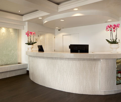 white front desk in modern white room with pink flowers
