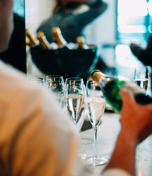 someone serving champaign in some glasses in an event