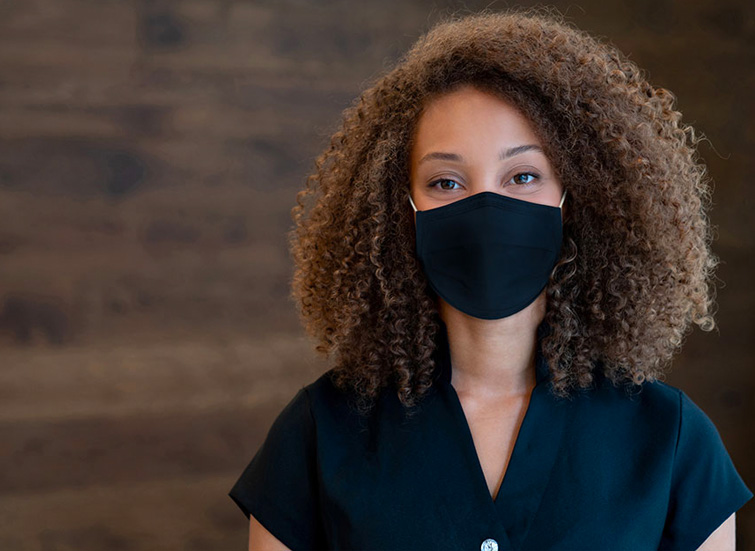 woman with black mask in front of wood wall