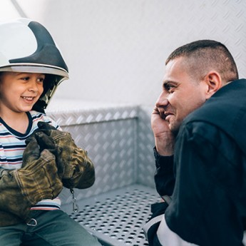 firefighter talking to a little boy