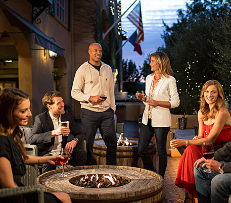 friends around a fire pit enjoying wine