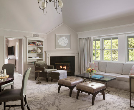a cream colored room with a sofa, a fireplace, a table and chairs
