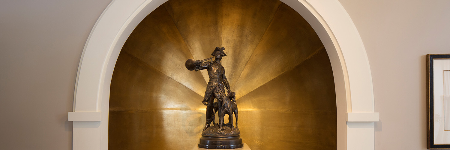 image of a statue of a man in front of a bronze wall