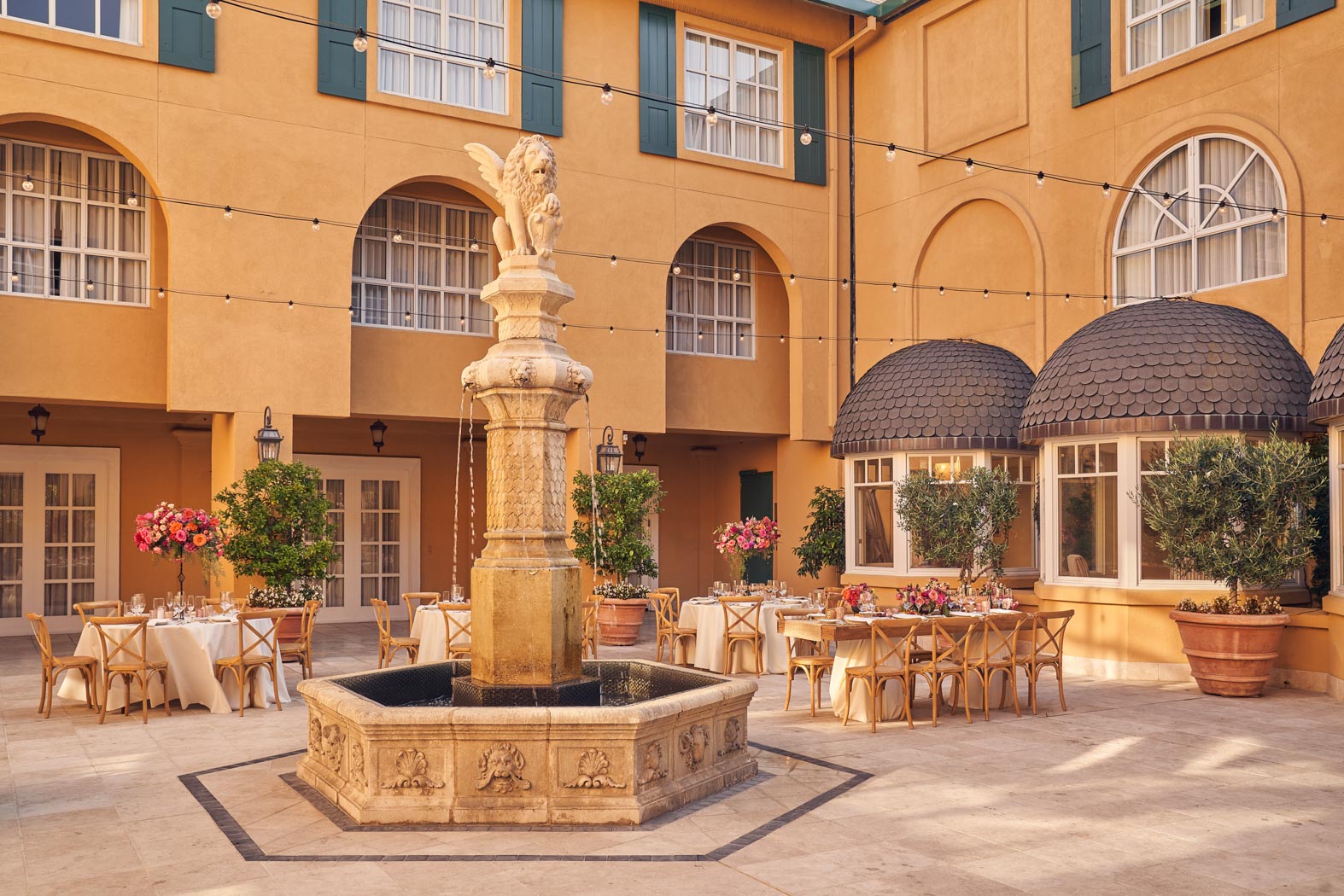 courtyard wedding with tables and chairs and fountain 