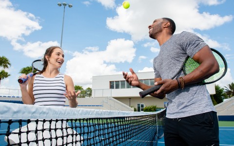 Two people playing tennis 