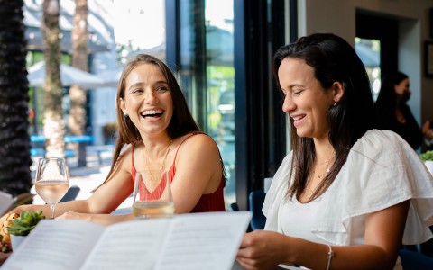 Two women dining and looking at the menu