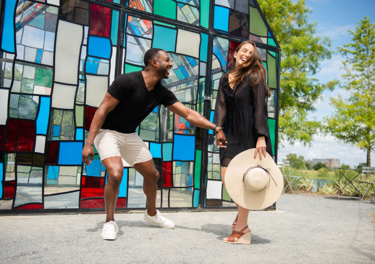 couple laughing in front of glass house