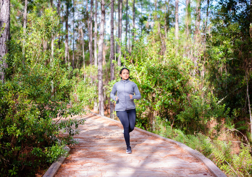 woman jogging on a trail in the forest