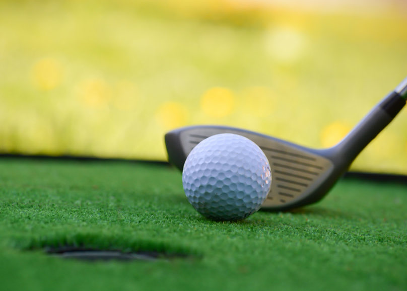close up of golf ball and golf club