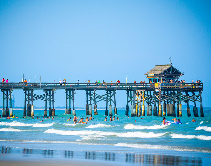 beach pier with people in the water 