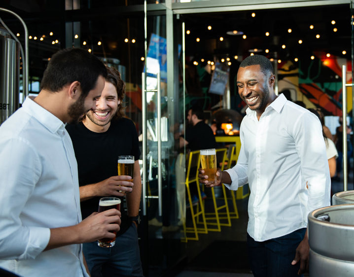 three men enjoying beer while laughing and talking 