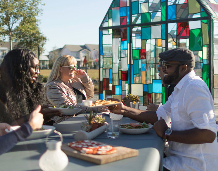 three people sitting down eating outside