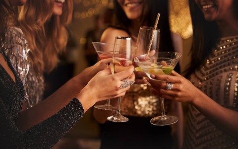 group of women clinking cocktails together