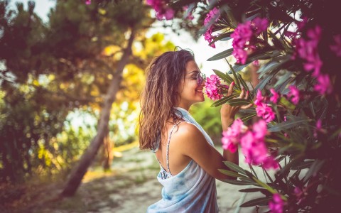 woman smelling beautifully pink flowers