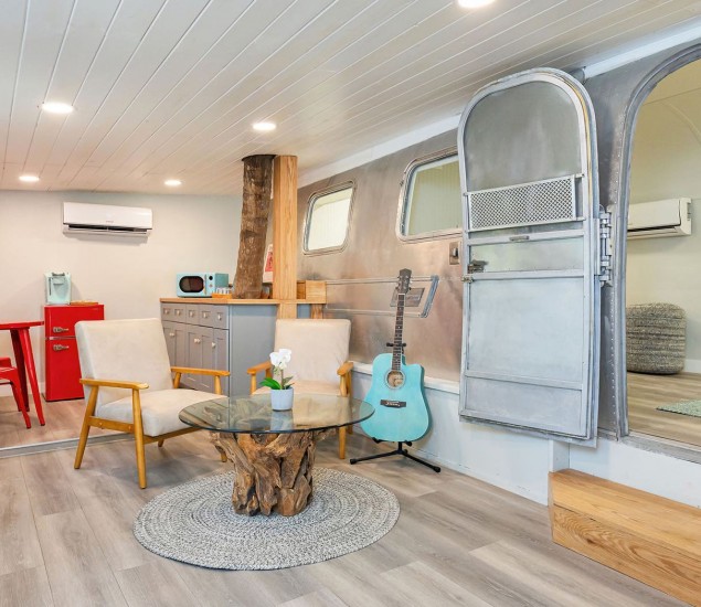 seating area near kitchenette with a metal wall and open door in airstream
