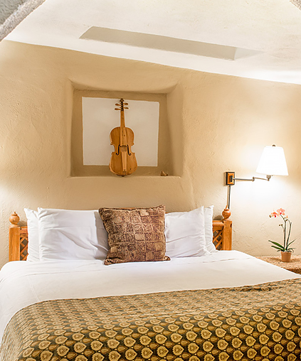 a room with lots of light and a violin displayed over the bed