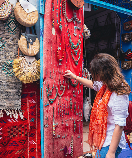a woman looking at handmade artwork hanging on a wall
