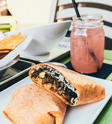 a close up of a wrap and a pink beverage