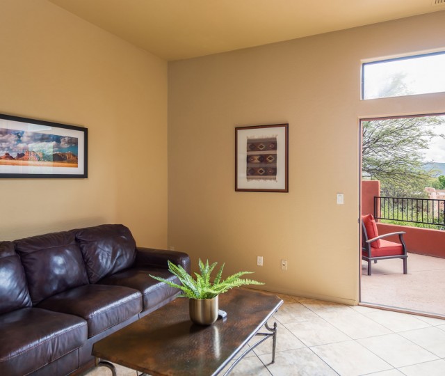 View of a large sofa and a tv, next to a private balcony