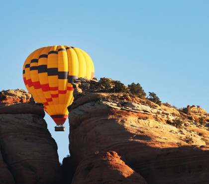 View of a hot air balloon next to a rocky mountain 