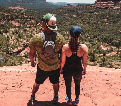A couple enjoying the landscape on top of a rocky mountain 