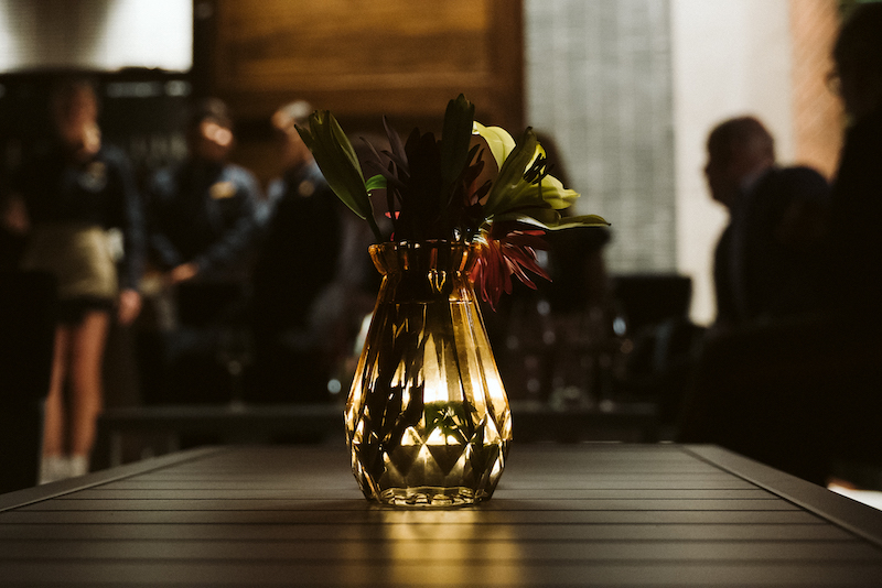 metallic vase filled with dark green and purple plants