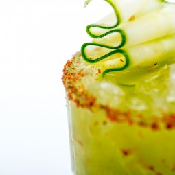 close up of a green cocktail with a spicy rim