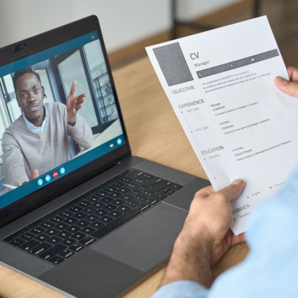 view of someone holding a resume in front of a virtual meeting call