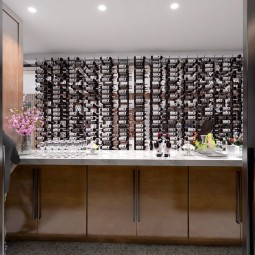 a wine tasting room with wooden furniture and lots of bottles of wine on the wall
